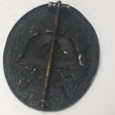 A German Third Reich Wound badge with medal ribbon and photograph of the recipient the reverse of the photo with hand written inscription 1943.