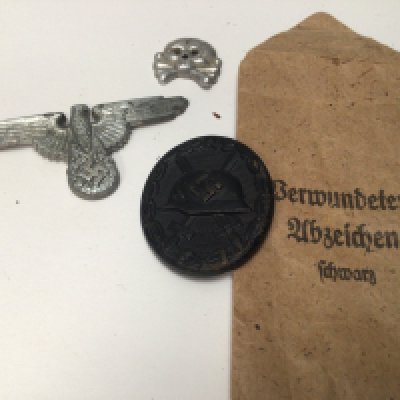 A German Third Reich Wound badge black finish reverse stamped 107 in original envelope an SS cap badge and Panzer badge (3)