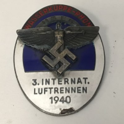 A Third Reich oval enamelled NSFK pin back badge, for &ldquo;3. Internat. Luftrennen 1940, Wasserkuppe Rhon&rdquo;, with white, blue and red enamel and superimposed NSFK device in the centre, the back embossed &ldquo;Ges Gesch&rdquo; GC Minor damage to the enamel