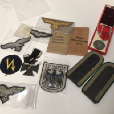 A 1914 steel cross German Third Reich cloth badges two envelopes no contents a civilian medal and a pair of officers epaulets