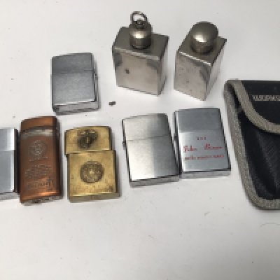 A collection of Zipo type lighters including a brass lighter with USA 1925 raised emblem.