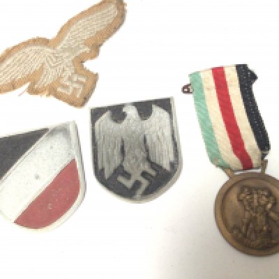 A German Third Reich Afrika Korps service medal cloth badge and metal badges.
