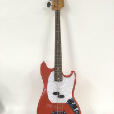 A Japanese Fender Mustang bass in fiesta red with a white pearloid scratchplate. Comes with a soft carry case. Not fitted.