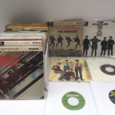 A collection of Beatles 7" singles and EPs including a Capitol pressing of 'Help!' and 'Money' / 'It Won't Be Long' on Odeon.