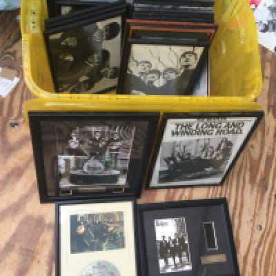 A box of framed Beatles pictures, film cels and metal signs.