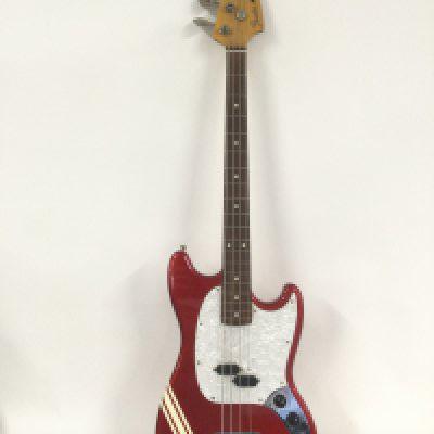 A Fender Mustang Bass guitar in a dakota red competition finish, made in Japan.