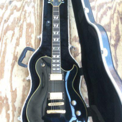 A Schecter Solo 6 Custom electric guitar with hard carry case.