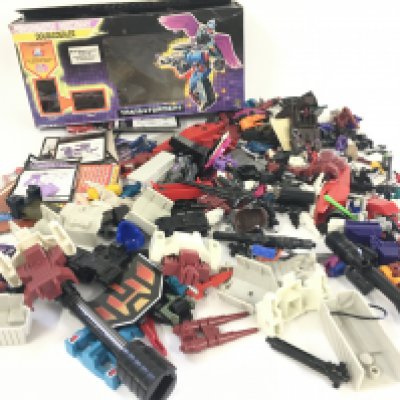 A collection of Transformers parts and accessories including an empty box and numerous instruction booklets