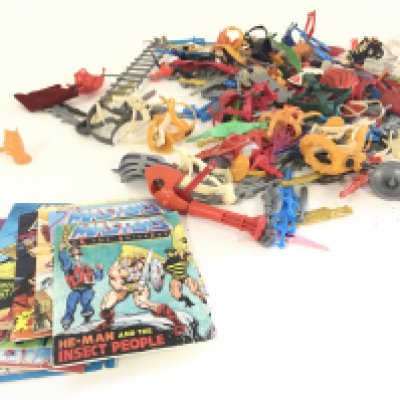 A collection of Masters of the Universe accessories and comics.