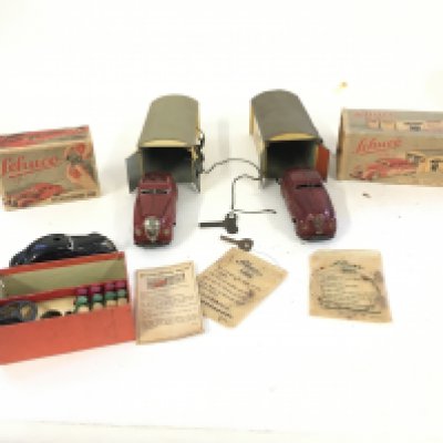 A collection of of 3 Playworn vintage Schuco toys includes two garages with cars and 1 telesteering car with instructions and accessories.