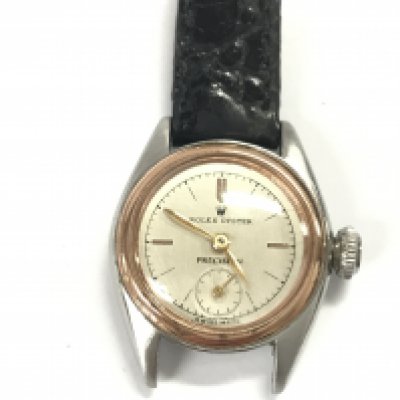 A vintage Rolex ladies Oyster Precision watch. Approximately 24mm case. Black leather strap. Comes with aftermarket box. Not seen running.