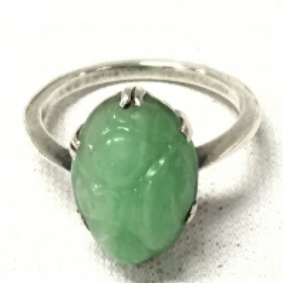 An unmarked white metal ring set with jade, ring size K. Postage cat A
