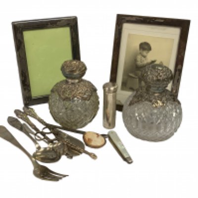 A mixed lot to include. Two hallmarked silver topped scent bottles, 2 Hallmarked silver picture frames, Hallmarkd silver cutlery etc.