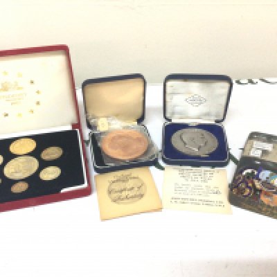 A cased set of 1992 Piedfort ECU coins a limited edition Britannia 1969 Investiture Medal 623/1500. and a tin of badges.