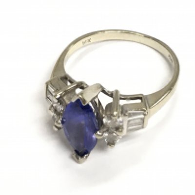 A 14ct white gold oval tanzanite with baguette and brilliant cut diamonds set on both shoulders. Approx weight 3.89 grams, size O.