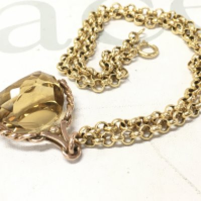 A 9ct rose gold spinning fob attached to a yellow metal belcher chain.