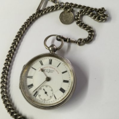 A silver case pocket watch with attached chain .
