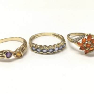 Three 9ct gold rings including an amethyst & citrine set ring size Q, light blue stone half eternity ring size R, Fire Opal set ring size R. 6.4g total weight. Postage category A