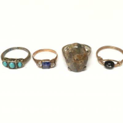 A collection of four assorted rings set with assorted gems and stone.