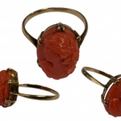 An Edwardian 9ct gold carved coral ring, Size P.