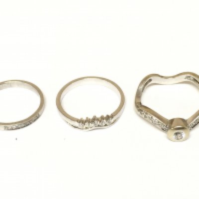 Three white unmarked rings two set with diamonds. Approximately 9g and sizes L 1/2 N 1/2 and R