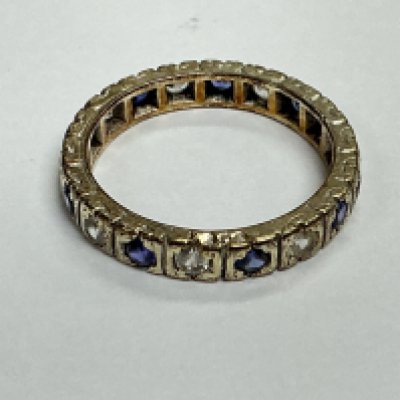 An unmarked eternity ring set with alternating small sapphires and diamonds. Approx size I 1/2, approx weight 2.38 grams.
