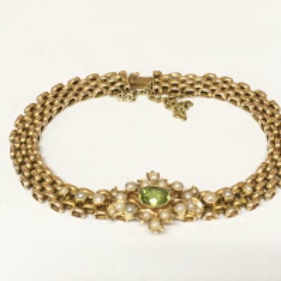 An Edwardian 15ct gold seed pearl and peridot bracelet. 16.40g