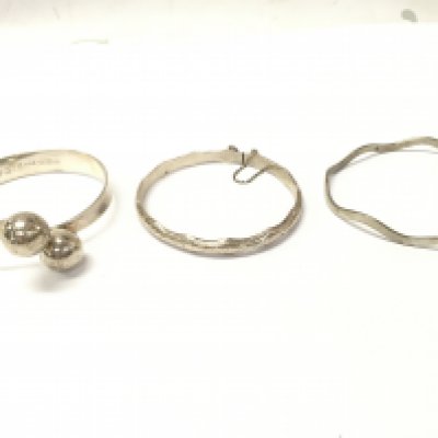 Two silver bangles and one metal. Postage category A