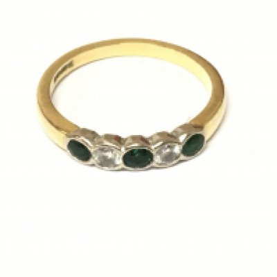 An 18ct gold five stone diamond and emerald ring. Size O and 3.07g