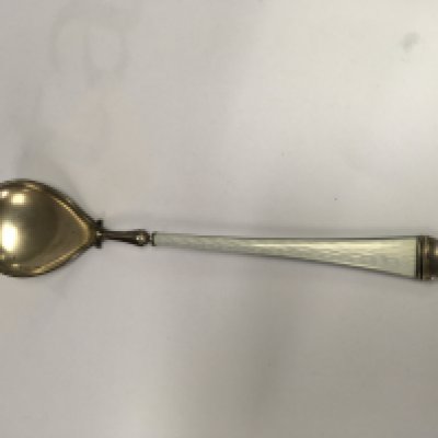 A silver and enamel spoon with tapering handle .
