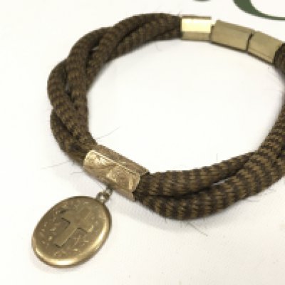 A Victorian hair bracelet with gold plated mounts