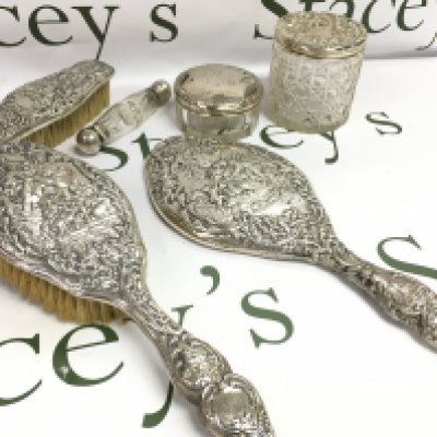 A silver dressing table set includes Brushes, glass jars, double ended scent bottle . This lot cannot be posted