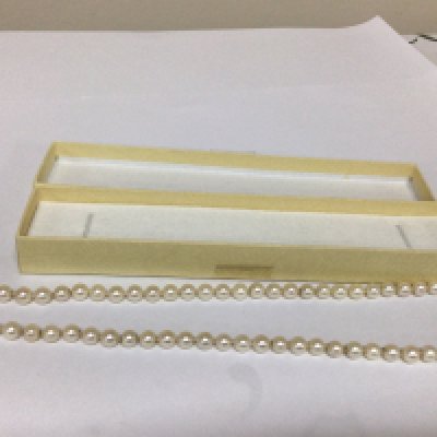 A Pearl necklace with an unmarked gold clasp set with an Amethyst length 48cm approximately. These are possible Mikimoto Pearls.
