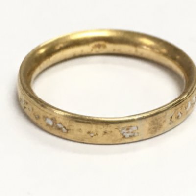 A yellow metal unmarked wedding band. 3.38g