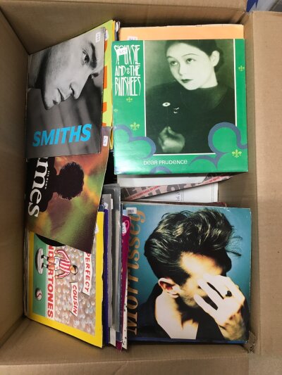 A box of 7" singles by various artists including The Smiths, REM, Buzzcocks and many more.