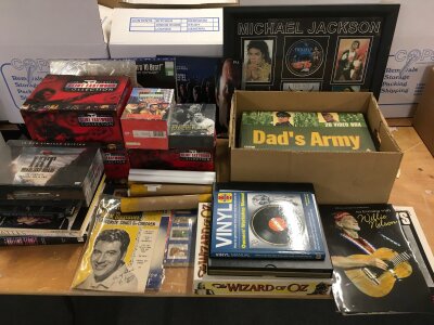 A collection of music, TV and film ephemera comprising sealed DVD box sets, tour programs, three laser discs, books, posters etc.