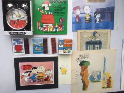 A collection of Peanuts cartoon and Snoopy related items comprising an LP signed by the main cast of the stage show in 1983, film cels, printed signatures of Charles M Schulz etc.
