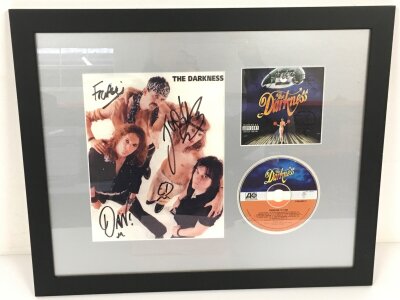 A framed and glazed fully signed CD display of The Darkness.