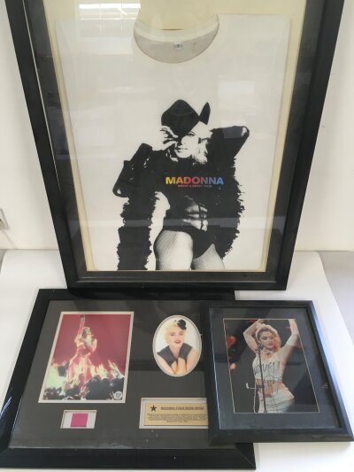 A framed and glazed signed photo of Madonna with COA, a framed display containing a fragment of a stage worn dress and a framed tour t shirt (3).