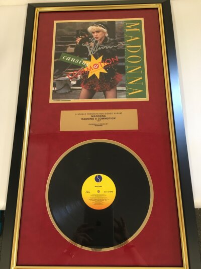 A framed and signed Madonna presentation display for the Causing A Commotion 12" single, Our Price PLC COA included. Approx 54cm x 95cm.