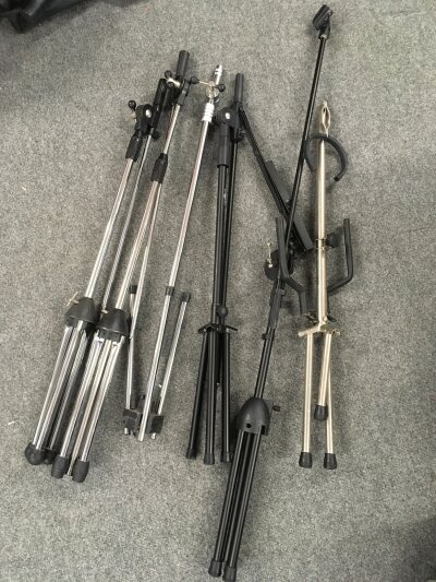 Four microphone stands including one fitted with a music sheet stand plus a guitar stand (5).