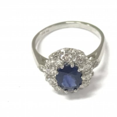 A platinum ring set with an oval sapphire a halo of diamonds and diamond set shoulders. Sapphire 1.50ct diamonds 0.85ct approximately. Size N