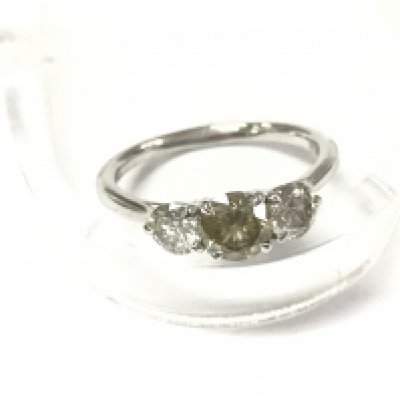 A platinum diamond trilogy ring set with a central fancy light brown diamond with flanking diamonds. Size N and comes with gemological report. Postage A