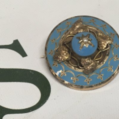 An Antique gold and pale blue enamel mourning brooch of oval shape with a central seed pearl. Unmarked.