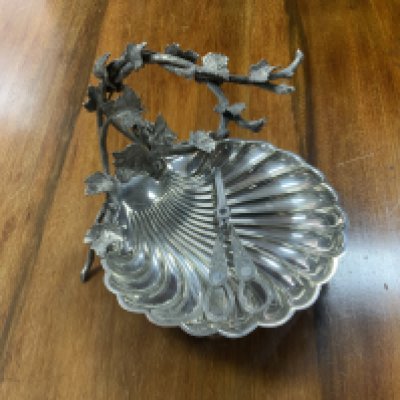 A silver plated grape dish with a grape vine design handle and scalloped shell design bowl together with a paid of gray scissors.