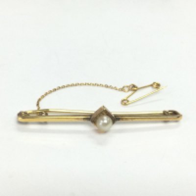 A 9ct gold brooch set with a central seed pearl, approx 2g. Shipping category A.