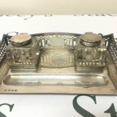 A Silver pen tray with a raised gallery and glass inkwells. On bun feet Birmingham hallmarks good condition.