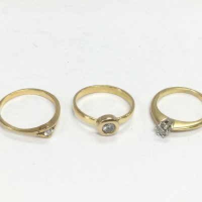 Three unmarked gold diamond solitaire rings, approx sizes M, L-M and I-J. Total approx 6.9g. Shipping category A.