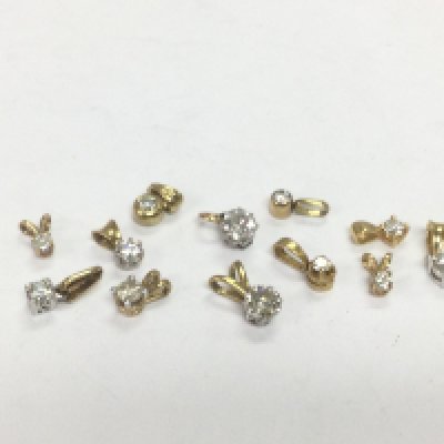 Twelve gold solitaire diamond pendants, total approx 4.6g. Shipping category A.