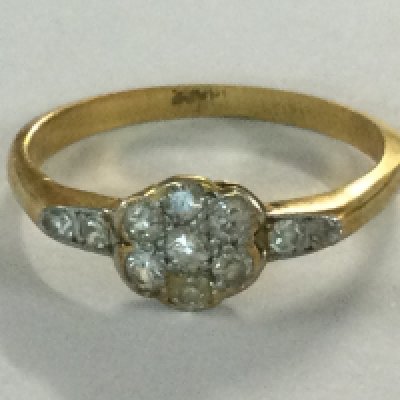 A gold ring of floral design inset with diamond chips